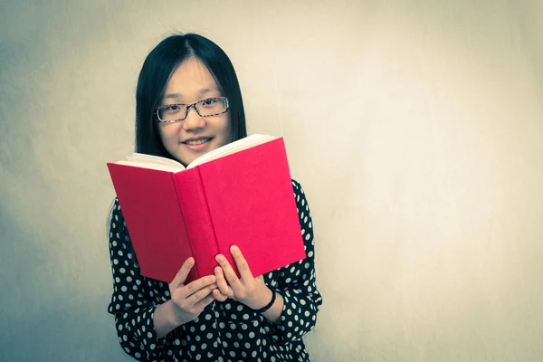 Mädchen liest ein rotes Buch — Stockfoto
