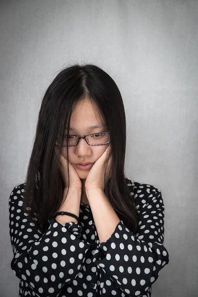 Depressed girl holding her face Stock Picture