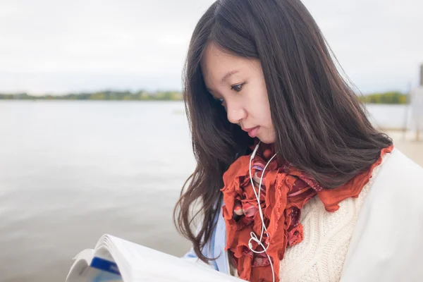 Ragazza lettura libro vicino lago — Foto Stock