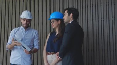 Ekip mühendisi enerji güneş pili paneli ile ortaklık, güç ve çevre kurulumu hakkında konuşuyor ve plan yapıyor, mimar enerjinin verimliliğini ve projenin yeniliğini gösteriyor.