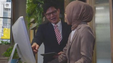 Girişimci, çalışanlarıyla konuşuyor ve ofiste birlikte masaüstü bilgisayarına bakıyor, yönetici ya da yönetici öğretmenlik yapıyor, iş kadını ile patron görevi, iş konsepti.