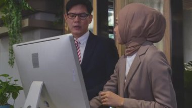 Girişimci, çalışanlarıyla konuşuyor ve ofiste birlikte masaüstü bilgisayarına bakıyor, yönetici ya da yönetici öğretmenlik yapıyor, iş kadını ile patron görevi, iş konsepti.