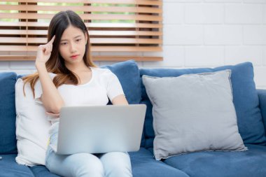 Genç Asyalı kadın evdeki koltukta dizüstü bilgisayarla çalışıyor. Hayal kırıklığına uğramış ve sıkılmış, serbest çalışan mutsuz ve yorgun bir kız. Başarısızlıktan, başarısızlıktan ve hatadan, iş konseptinden rahatsız..