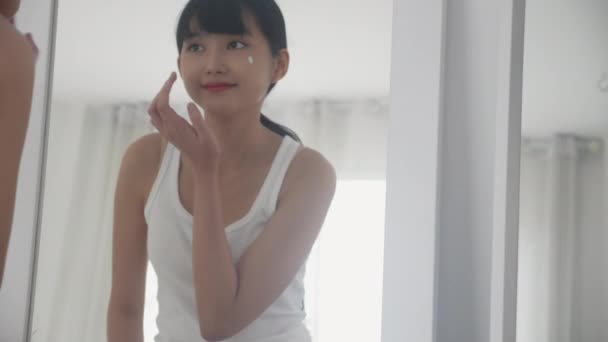 Krásná Mladá Asijská Žena Dívá Zrcadla Aplikovat Hydratační Krém Kosmetickým — Stock video