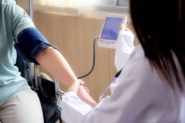 穿制服的女医生与老年患者一起测量血压 以检查脉搏健康和医院检查 医生和保健 种族多样性 医疗观念 — 图库照片