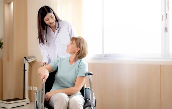 妇女医生鼓励和照顾老年人坐在医院的轮椅上 对老年人友好的医生 诊断疾病 医疗保健 室内护理 医疗概念 — 图库照片