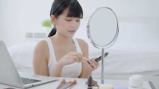 在网上看笔记本电脑和辅导课 在网上教女生化妆 在流媒体上解释化妆品的年轻亚洲女人的美丽 — 图库视频影像