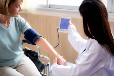 Üniformalı doktor kadın hastane, doktor ve sağlık hizmetleri, etnik çeşitlilik, tıbbi konsept, sağlık ve nabız kontrolü için yaşlı hastalarla kan basıncını ölçüyor..