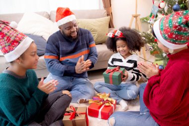 Mutlu aile babası ve anne, Noel 'de evde kızıyla birlikte hediye kutlaması yapıyor. Mutlu Noel arifesi, mutlu Noel arifesi, mutlu Noel' ler..