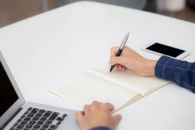 İş adamının eli, evdeki dizüstü bilgisayarı kullanırken notta yazdığı gibi, erkek iş başarısı, yazar ve blog, masa, çalışan ve iş için çalışan işadamı,.