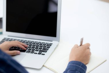 İş adamının eli, evdeki dizüstü bilgisayarı kullanırken notta yazdığı gibi, erkek iş başarısı, yazar ve blog, masa, çalışan ve iş için çalışan işadamı,.