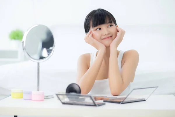 幸せな笑顔とタッチ頬を持つ若いアジアの女性の美しい顔は魅力的な鏡を見て スキンケアと化粧品の治療 スキンケアと健康的な概念を持つ美顔の女の子のメイク — ストック写真