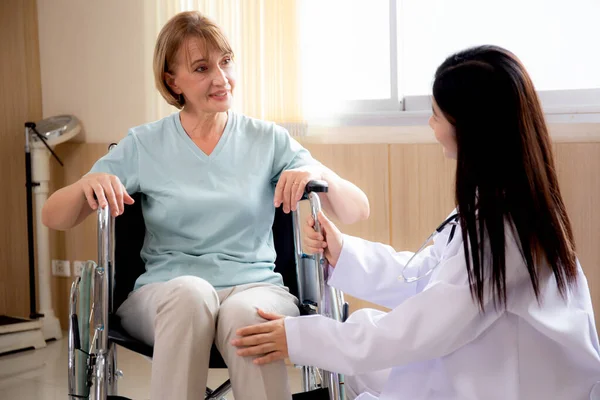 妇女医生鼓励和照顾老年人坐在医院的轮椅上 对老年人友好的医生 诊断疾病 医疗保健 室内护理 医疗概念 — 图库照片
