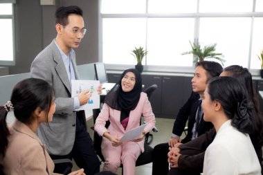 Genç işadamı, ofisteki konferansta finans, yürütme planlaması ve çalışanlarla birlikte yatırım, iş konsepti ve grafik raporu sundu.