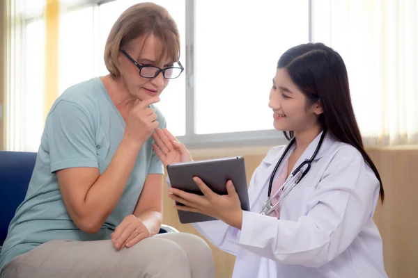 Ärztin Und Seniorin Sprechen Und Schauen Auf Tablet Computer Zur — Stockfoto