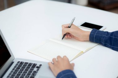İş adamının eli, evdeki dizüstü bilgisayarı kullanırken notta yazdığı gibi, erkek iş başarısı, yazar ve blog, masa, çalışan ve iş için çalışan işadamı,.