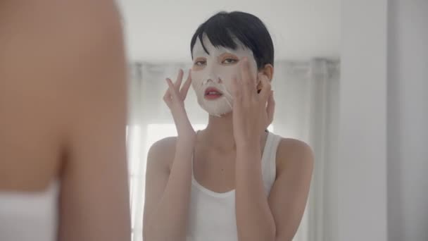 Beautiful Young Asian Woman Sheet Facial Mask Looking Mirror Home — Stock Video