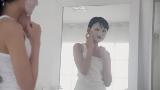 Beautiful Young Asian Woman Sheet Facial Mask Looking Mirror Home — Stock Video