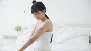Güzel, genç Asyalı bir kadın koluna nemlendirici sürerek ya da krem sürerek mutlu oluyor. Güzellik asyalı bir kız cildine makyaj yapıyor. Hijyen, kırışıklık ve cilt bakımı için..