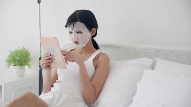 Hermosa Mujer Asiática Joven Con Mascarilla Facial Hoja Sentado Viendo — Vídeos de Stock