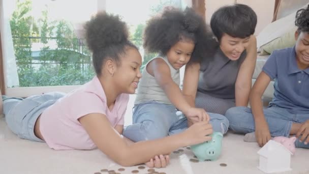 幸福的非洲家庭 母亲和孩子都在储蓄罐里存钱 为将来的经济成功 存款和投资 家庭生活 商业和金融概念规划开支 — 图库视频影像