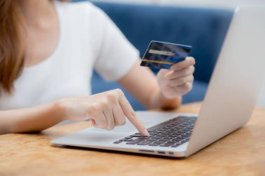 Bilgisayarla kredi kartı alışverişi yapan genç bir kadının eli, İnternet, ticaret ve e-ticaret, finans alışverişi, iş konsepti.