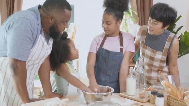 非洲裔美国人家庭在家里的厨房里一起穿围裙做饭和打粉 父母和小孩一起玩乐做饭 男女关系和爱好 家庭生活 — 图库视频影像