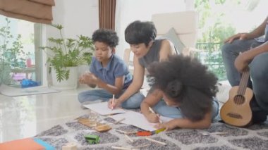 Anne ve babayla mutlu bir aile renkli kalemlerle çizim yapan çocuklar ve evde birlikte oturma odasında, öğrenim için aktivite ve hobi, eğitim kavramı..