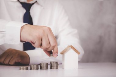 İş adamlarının elleri ve emlak ve başarı, finans ve yatırım, sigorta evi, depozito ve mülk, konut ve finans, iş konsepti için tasarruf edilen para yığını.