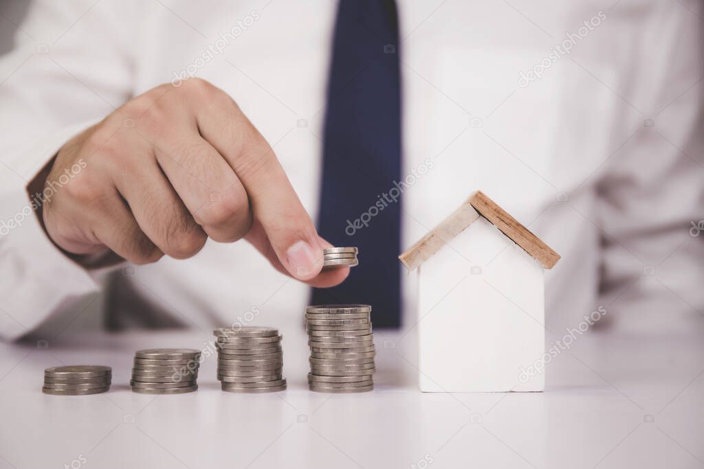 Hands of businessman and stack of coin with saving money for real estate and success, finance and investment, insurance home, deposit and property, residential and financial, business concept.