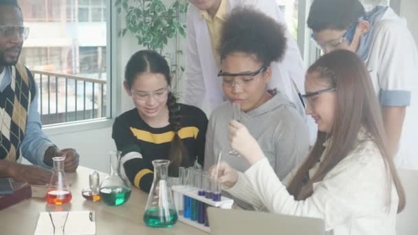 青年教师班组学生在学校实验室学习科学 讲解液体化学 儿童在实验室学习实验科学 教育观念 — 图库视频影像