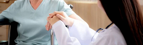 妇女医生鼓励老年人坐在医院的轮椅上 手牵手抚慰老年人 诊断疾病 医疗观念 — 图库照片