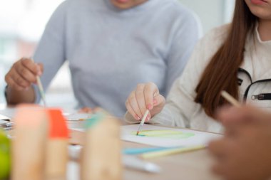 Kapanış grubu öğrencilerden oluşan bir grup, okulda öğretmenle birlikte oturuyor, çalışıyor ve resim çiziyor, öğrencilerin çizim için yaratıcılığı, okula dönüş, eğitim kavramı..