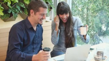 Kafede dizüstü bilgisayarda çalışan genç bir çift, kadın ve erkek kahve dükkanında buluşuyor ve tartışıyorlar, erkek ve kız arkadaş defter bakıyor ve kahve içiyor, iş konsepti.