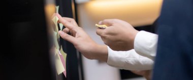 İş adamlarının ve meslektaşlarının ofis planlama ve pazarlama stratejisi için yakın çekim elleri, post it etiketi ve iş konsepti üzerine yazılı yaratıcı ekip toplantısı.