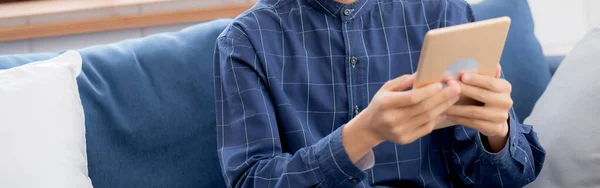Mladý Atraktivní Asijský Muž Odpočívající Pomocí Prohlížení Tabletu Počítače Pohovce — Stock fotografie