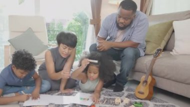 Anne ve babayla mutlu bir aile renkli kalemlerle çizim yapan çocuklar ve evde birlikte oturma odasında, öğrenim için aktivite ve hobi, eğitim kavramı..