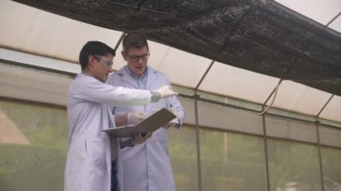 Kimyasal ve dizüstü bilgisayarlı iki bilimadamı çiftlikteki tarım, botanik ve ürün hasadı ile ilgili araştırmacılar ve bahçıvanlık alanında biyoloji ve bilim araştırmaları yapıyor..
