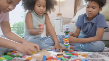 Çocukların olduğu mutluluk ailesi, eğlence ve eğlence ile birlikte yerde blok tahtası oynuyorlar ve evdeki oturma odasında rahatlıyorlar. Rekabet ve gelişim ve öğrenim için aktivite ve hobi, yaşam tarzı konsepti..