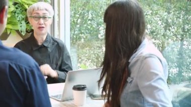 Üst düzey kadın proje anlaşmasından ve kafedeki iş adamlarına açıklama yapmaktan, yaşlılarla konuşmaktan ve kahve dükkanındaki iş ortaklığından, danışman ve temsilcilikten bahsediyor..