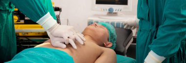 Doktor ve cerrahın elleri göğsüne kalp masajı yapıyor. Hastanedeki ameliyatta, kardiyolojide ve tedavide, acil ve canlandırmada, tıbbi ve sağlıkta acil kalp masajı yapılıyor..