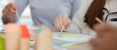 Kapanış grubu öğrencilerden oluşan bir grup, okulda öğretmenle birlikte oturuyor, çalışıyor ve resim çiziyor, öğrencilerin çizim için yaratıcılığı, okula dönüş, eğitim kavramı..