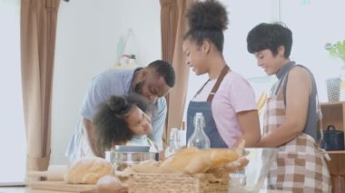 Afro-Amerikan ailesi evde ekmek ya da fırın pişirmek için önlük takıyor ve birlikte yemek pişiriyor, ebeveyn ve küçük çocuk yemek hazırlıyor, aile ve hobi ilişkisi, ev hayatı..