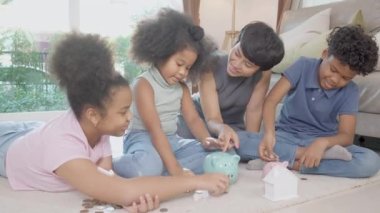 Anneleri ve çocukları olan Afrikalı mutlu bir aile domuzcuk bankasında mali başarı, depozito ve yatırım, iç hayat, iş ve finans kavramının gelecekteki masraflarını planlamak için para biriktiriyor..