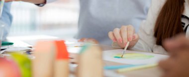 Kapanış grubu öğrencilerden oluşan bir grup, okulda öğretmenle birlikte oturuyor, çalışıyor ve resim çiziyor, öğrencilerin çizim için yaratıcılığı, okula dönüş, eğitim kavramı..