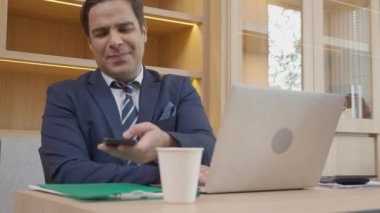 Yönetici ya da yönetici dizüstü bilgisayarla uğraşmakla ve ofisteki başarının yanı sıra akıllı telefonlardan konuşmakla meşgulken, iş adamlarının şirket ve iş konseptinden emin telefon görüşmeleri.