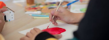 Kapanış grubu öğrencilerden oluşan bir grup, okulda öğretmenle birlikte oturuyor, çalışıyor ve resim çiziyor, öğrencilerin çizim için yaratıcılığı, okula dönüş, eğitim kavramı..