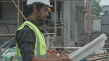 Müteahhitlerden oluşan bir grup mühendis ve mimar, planlama projesinden işçiye planlama sahasına, şablona, inşaat sahasına, geliştirmeye ve yapıya bakıyorlar..