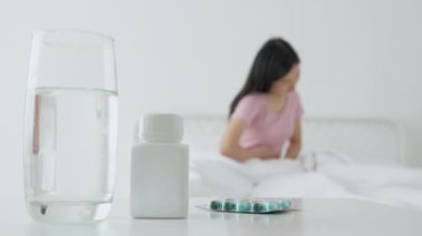 Genç Asyalı bir kadın yatak odasında hasta ve adet ve mide ağrısı, tıbbi ve sağlık konsepti, mide ağrısı, mide ağrısı, bağırsak ya da hastalıklı kabızlık veya hazımsızlık ile evde oturuyor..