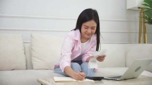 年轻的亚洲妇女在家里带着计算器计算金融家庭 女孩在储蓄和规划费用 债务和贷款 税务和会计 商业和金融概念方面的支票账单 — 图库视频影像